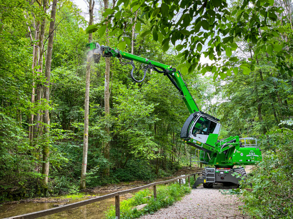 The 718 E tree care handler succeeds in felling the ash trees without impairing the course of the stream