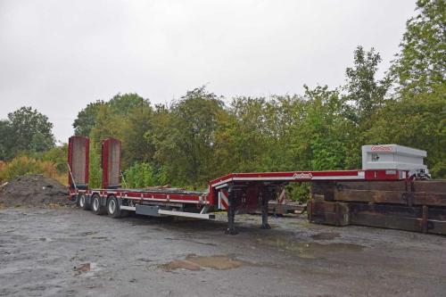 Low loader with 3 axle steering parked in yard