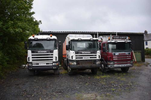 Three Scania trucks parked in yard
